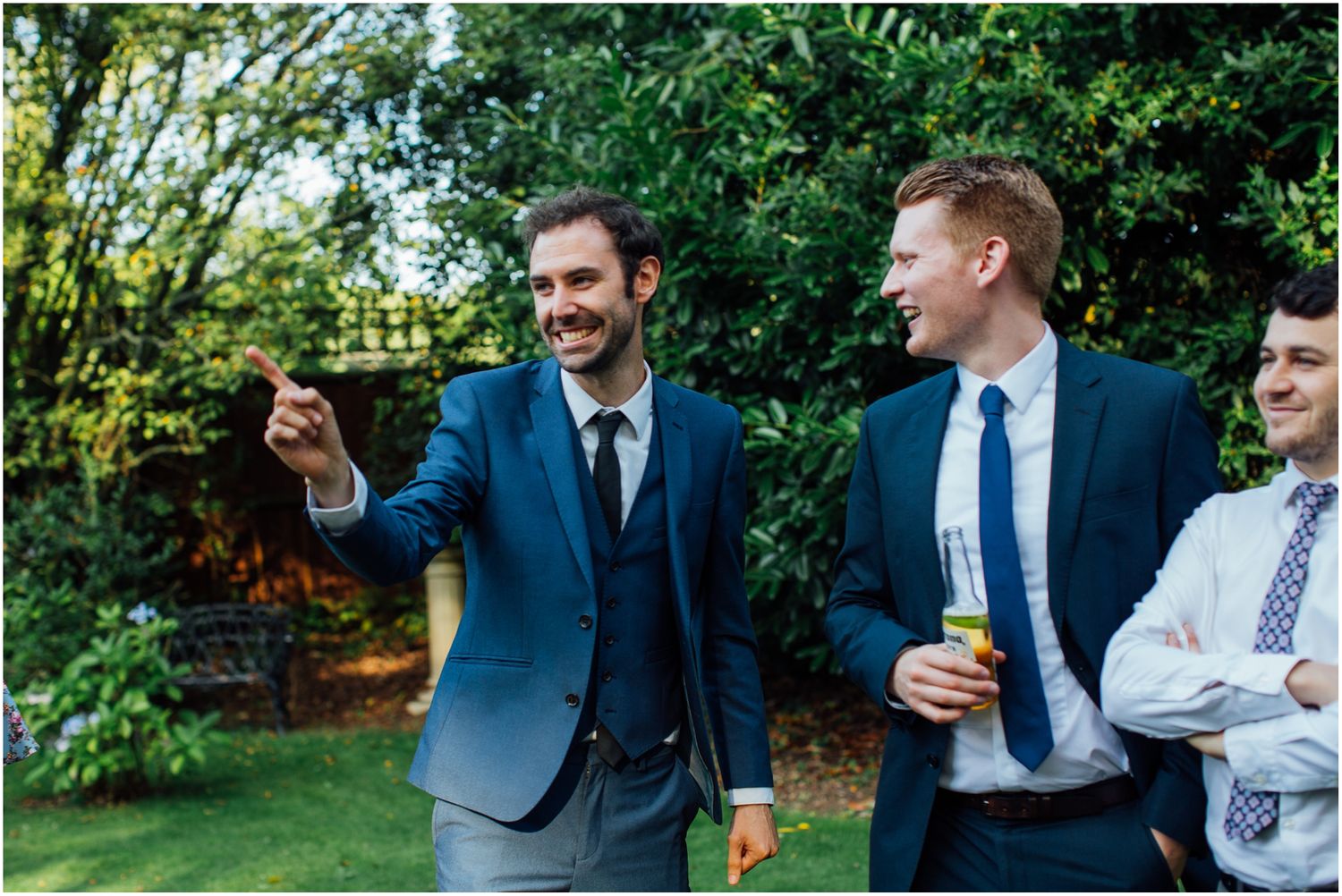 Guests in formal attire mingling at an outdoor wedding reception.