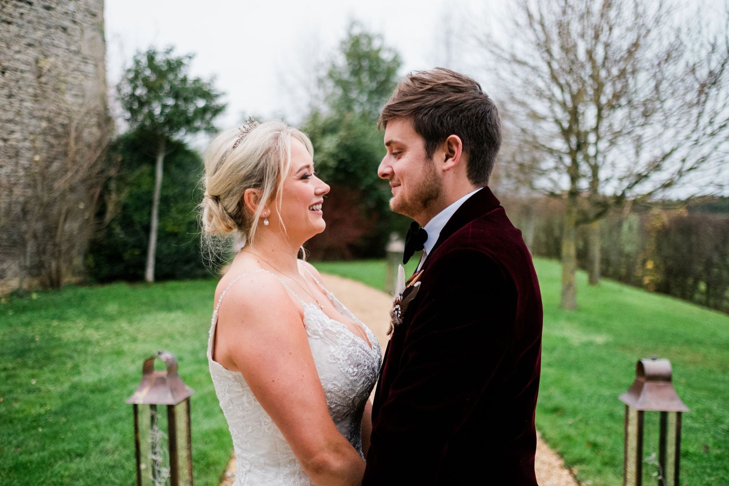 Newlyweds sharing intimate moments together on rolling green hills during their wedding day.