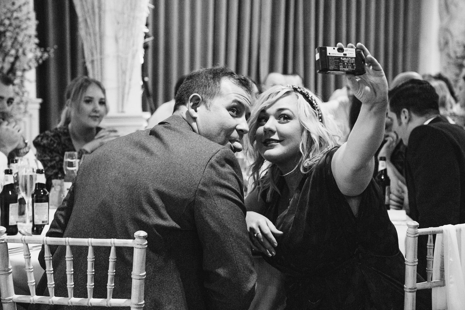 Wedding guests enjoying a celebration in an elegant indoor venue with festive atmosphere.