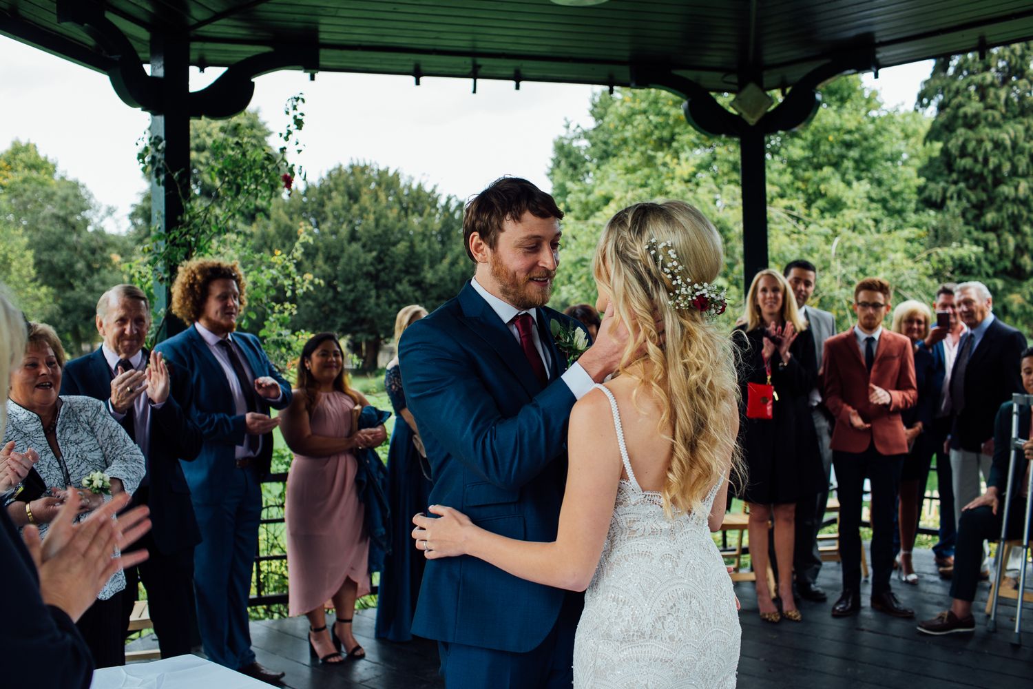 Wedding celebration under a covered outdoor pavilion with guests mingling and dancing.