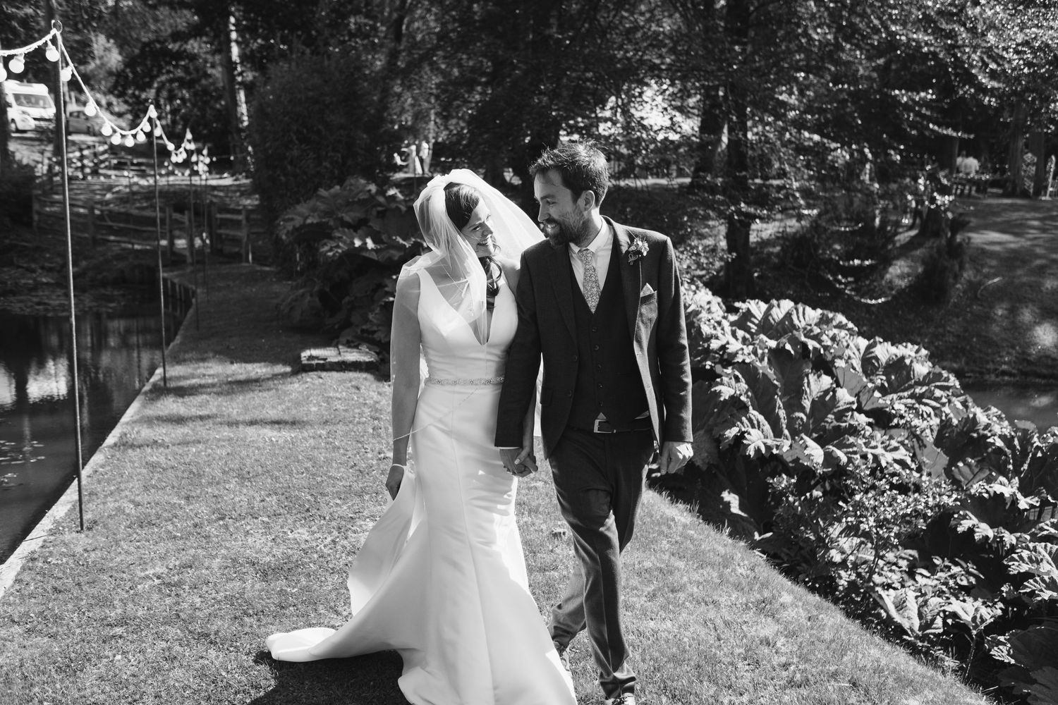 Black and white wedding photography captures romantic moments in a garden setting.