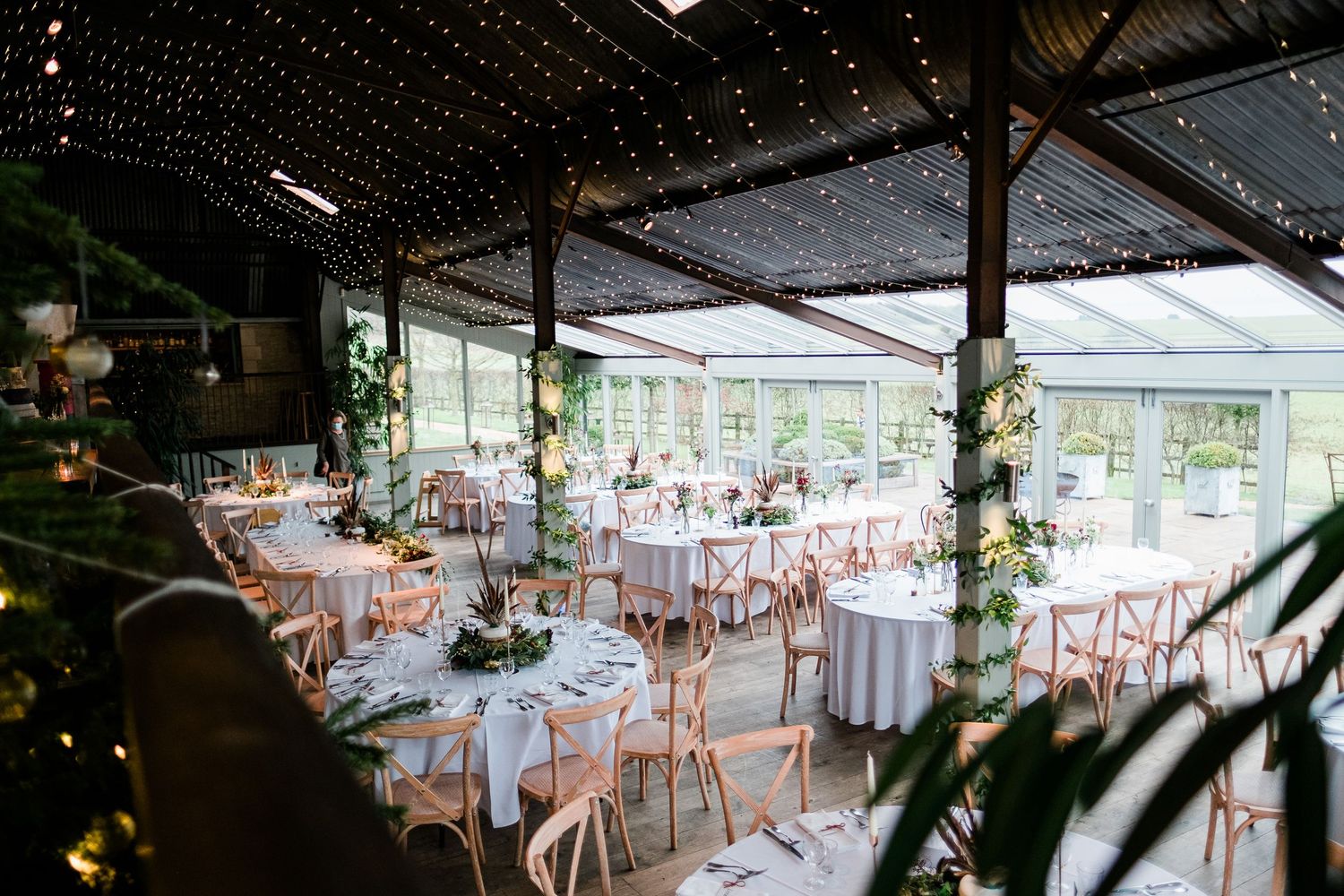 Wedding reception space with elegant table settings and natural light streaming in.