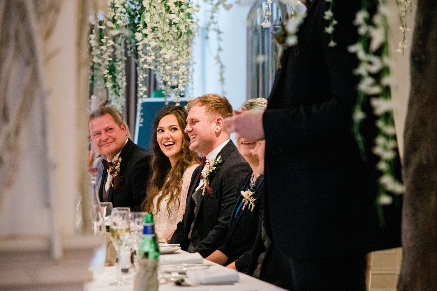 Wedding ceremony in a historic stone chapel with floral decorations and gathered guests.