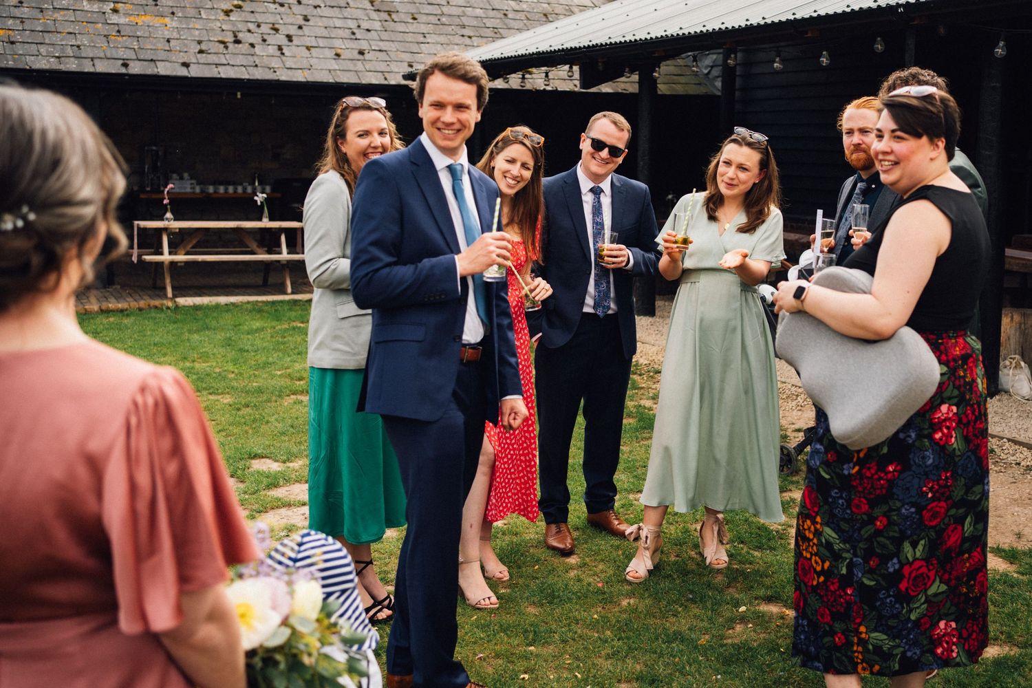 Outdoor wedding reception gathering with guests mingling on a lawn.