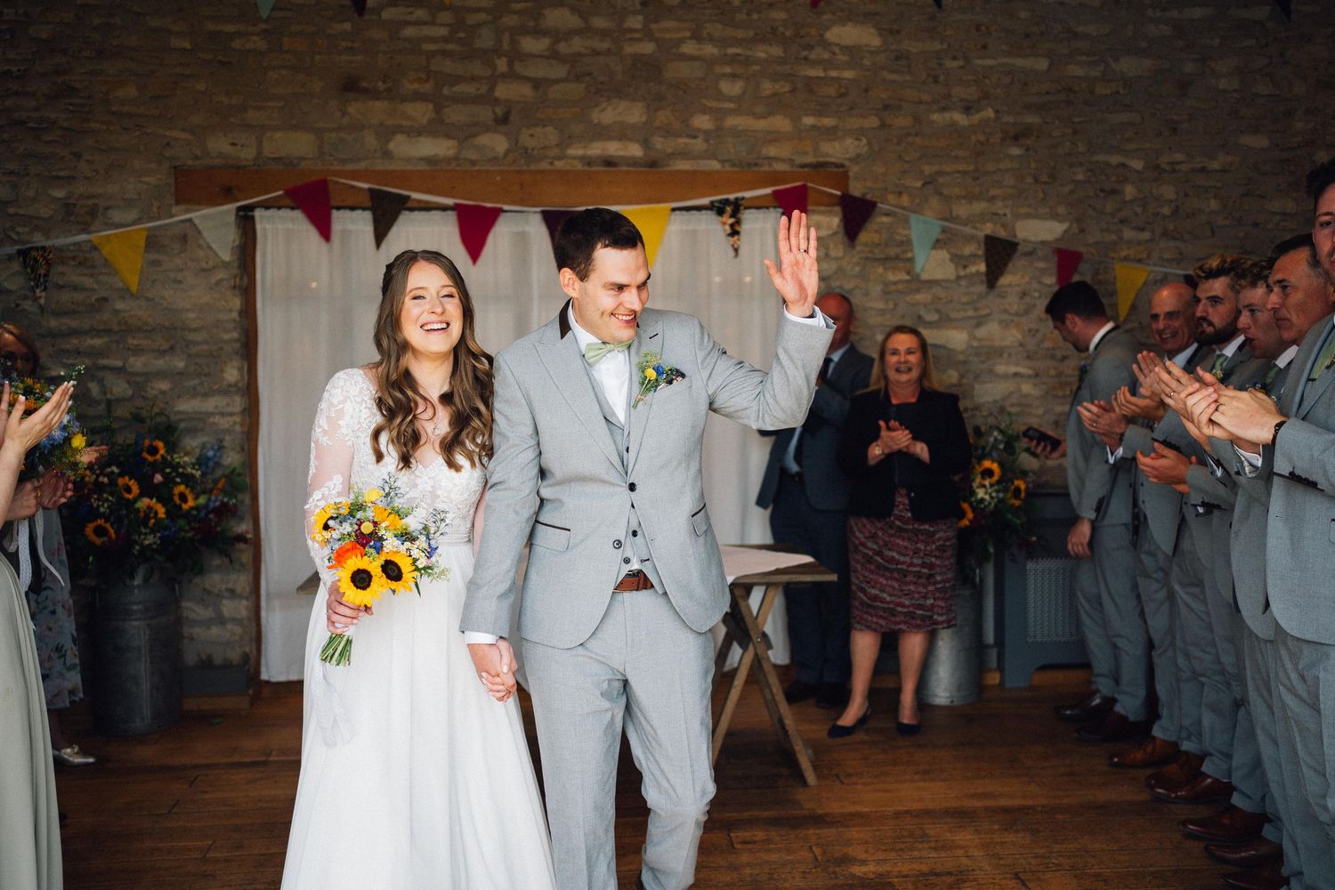 Wedding celebration in a rustic stone barn with decorative bunting overhead.