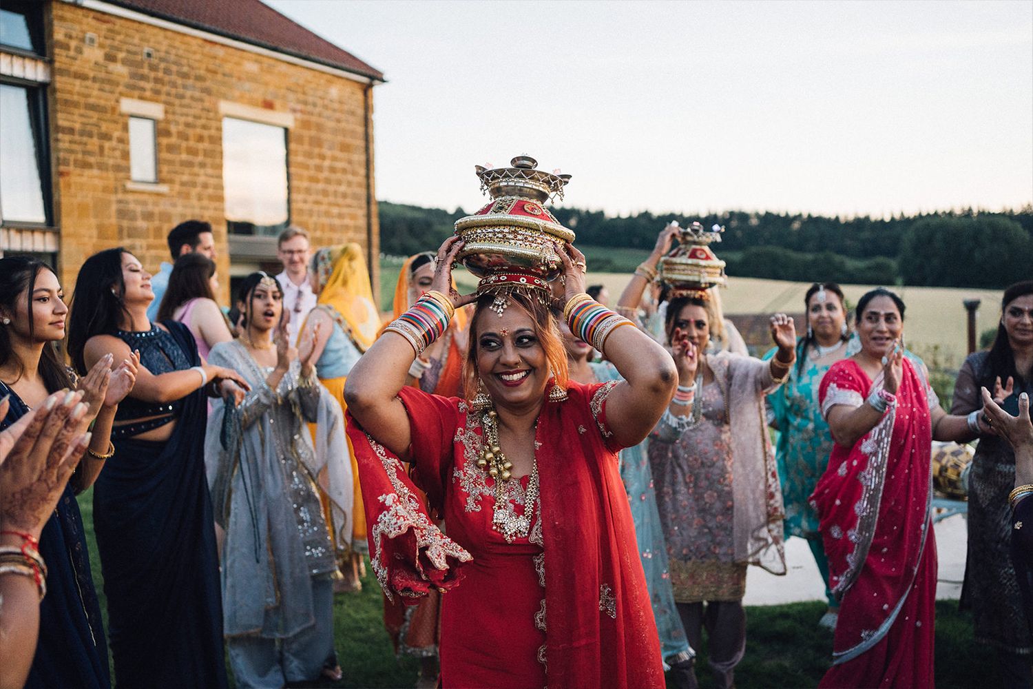 Wedding guests celebrate joyfully with bubbles outside a brick church building at an outdoor celebration.