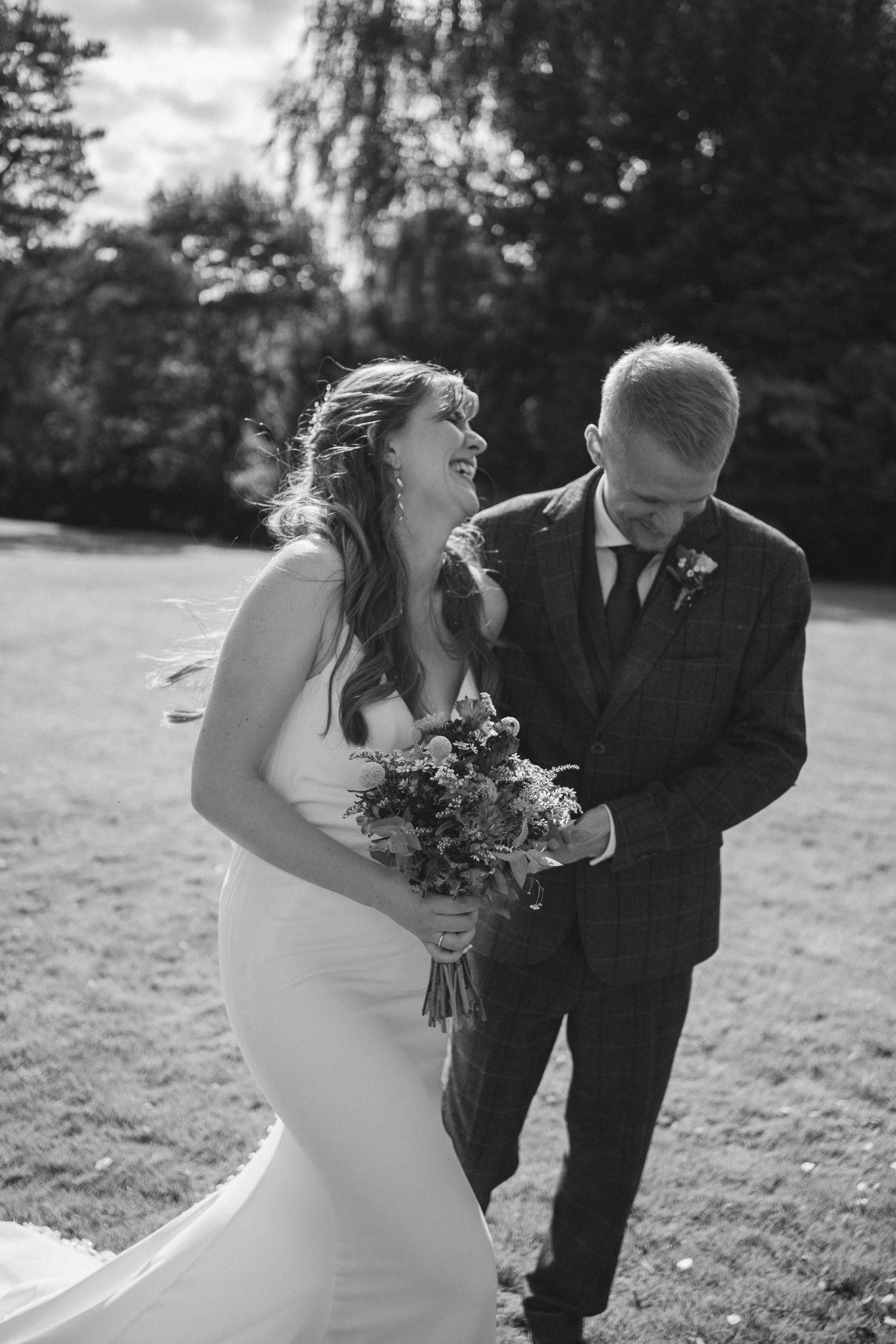 Black and white candid wedding photos showing joyful moments in an outdoor setting.