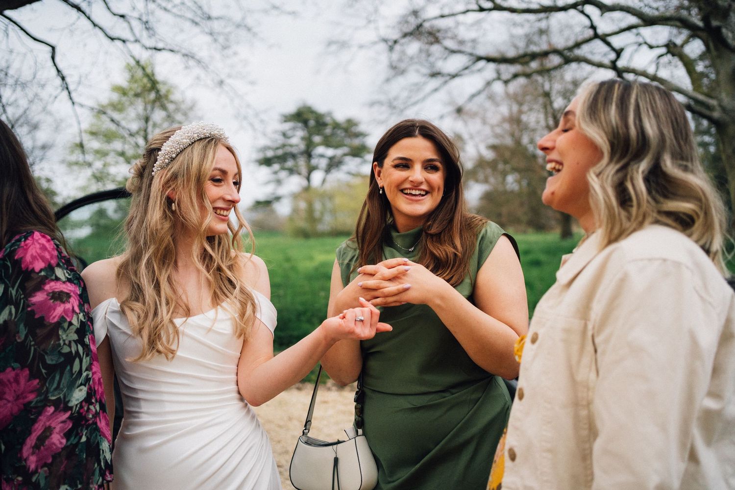 Candid moment of three guests sharing laughter during outdoor wedding festivities.