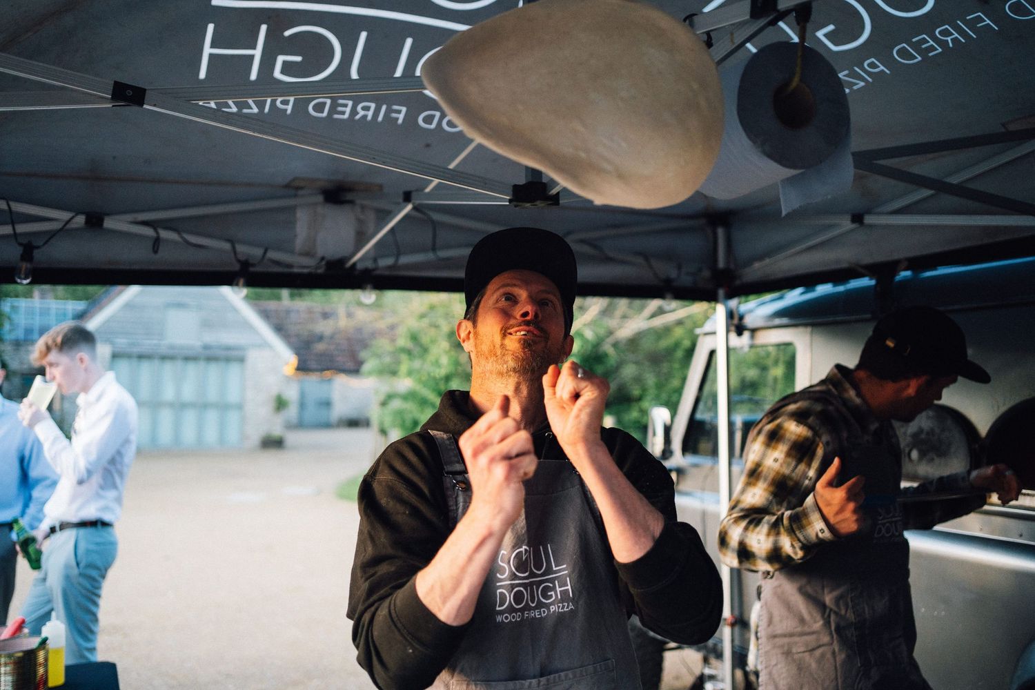 Vendors working under canopy tents at an outdoor catering setup.