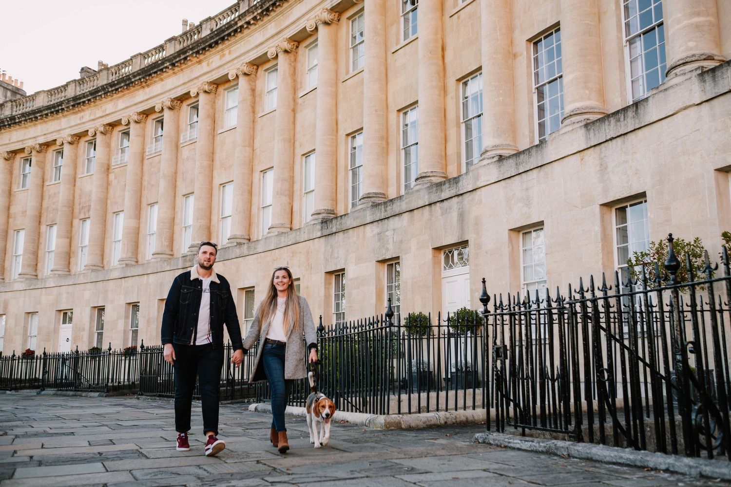The curved facade of Bath's Royal Crescent with people walking in the foreground.