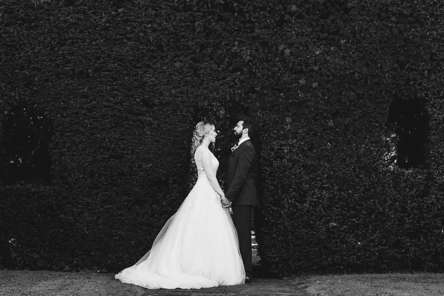 A couple in wedding attire dances together during their first dance at an elegant indoor reception.