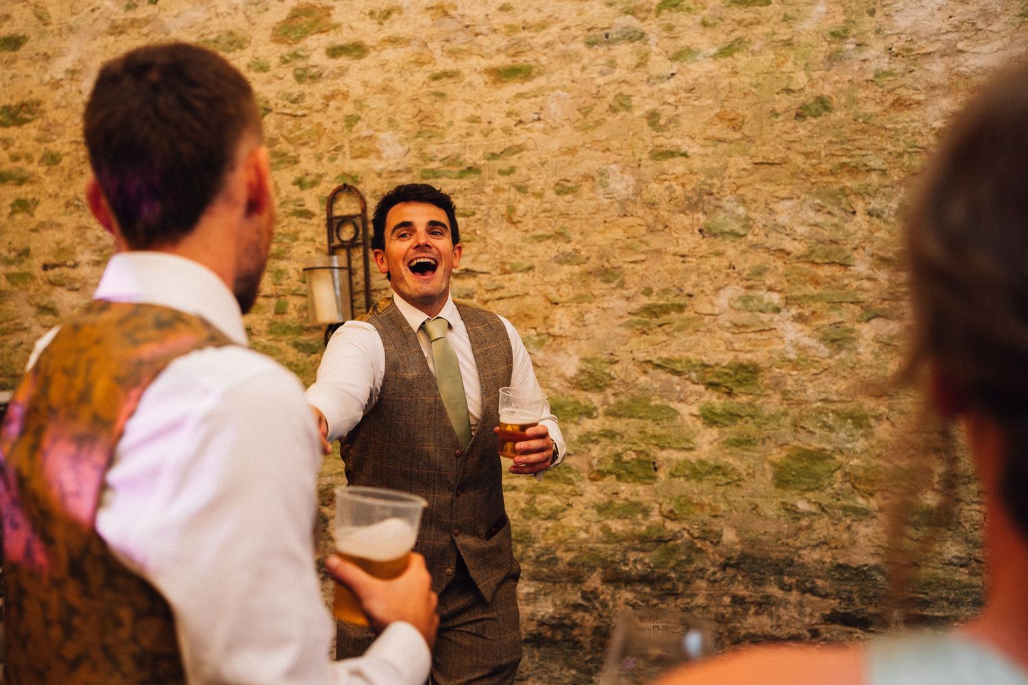 Guests enjoying a lively celebration in a stone-walled venue with festive lighting.
