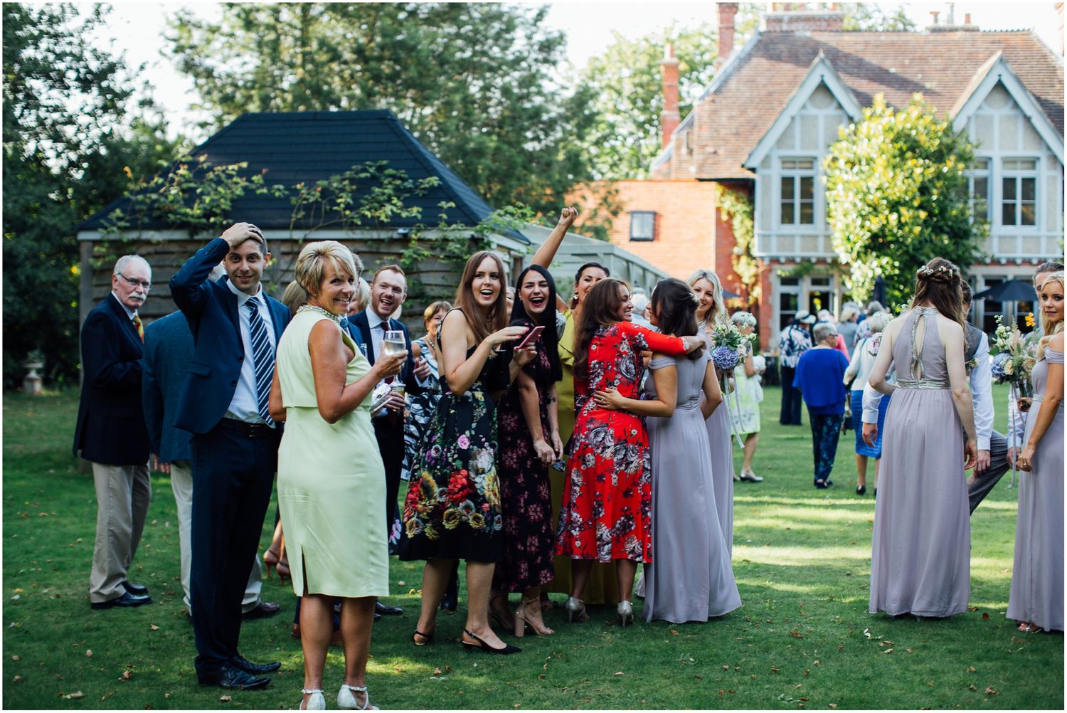Wedding celebration taking place in a backyard garden setting with white tents.