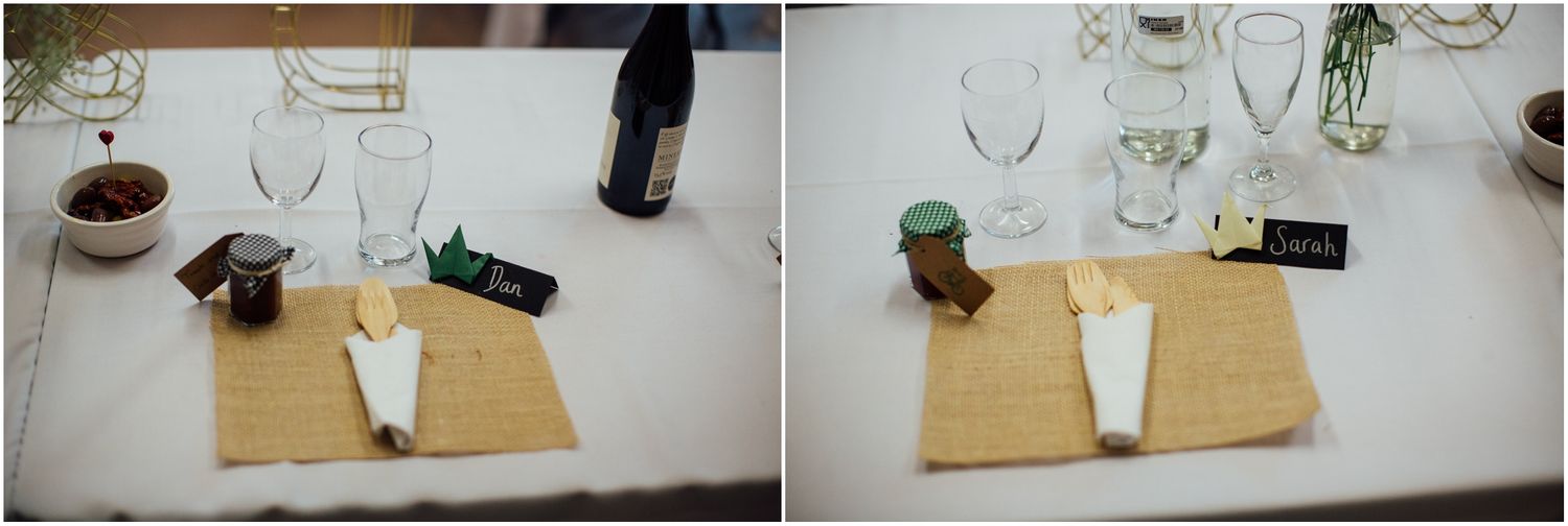 Rustic table settings with wine glasses and place cards at a wedding reception.