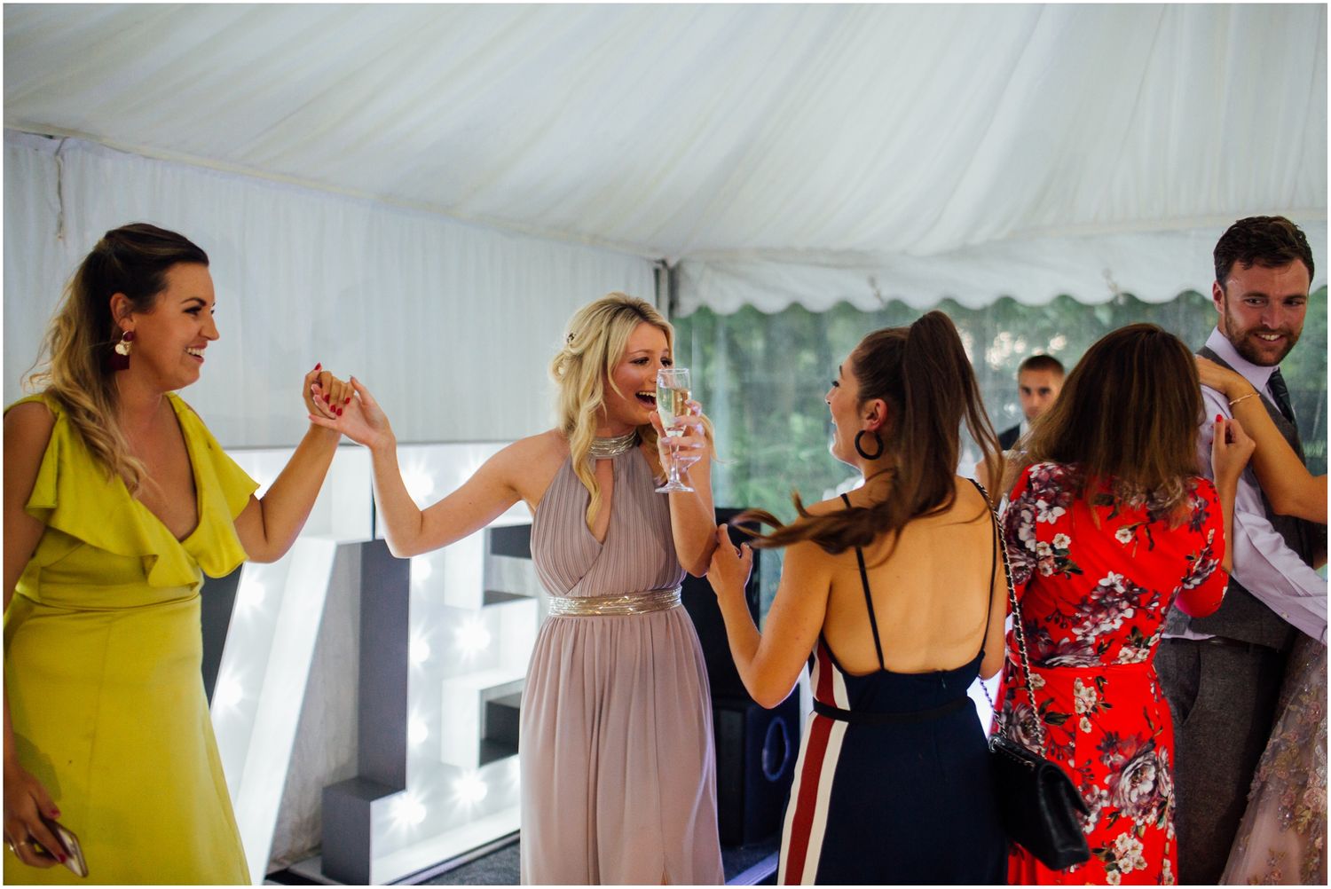 Guests enjoying themselves on the dance floor at an outdoor wedding reception.