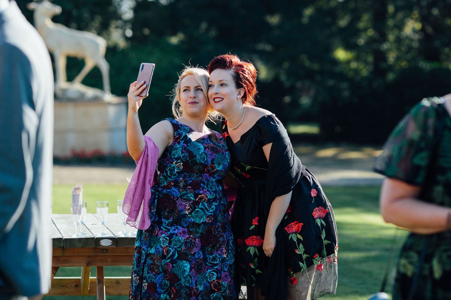 Wedding attendees socialize on a grassy lawn during an outdoor reception.
