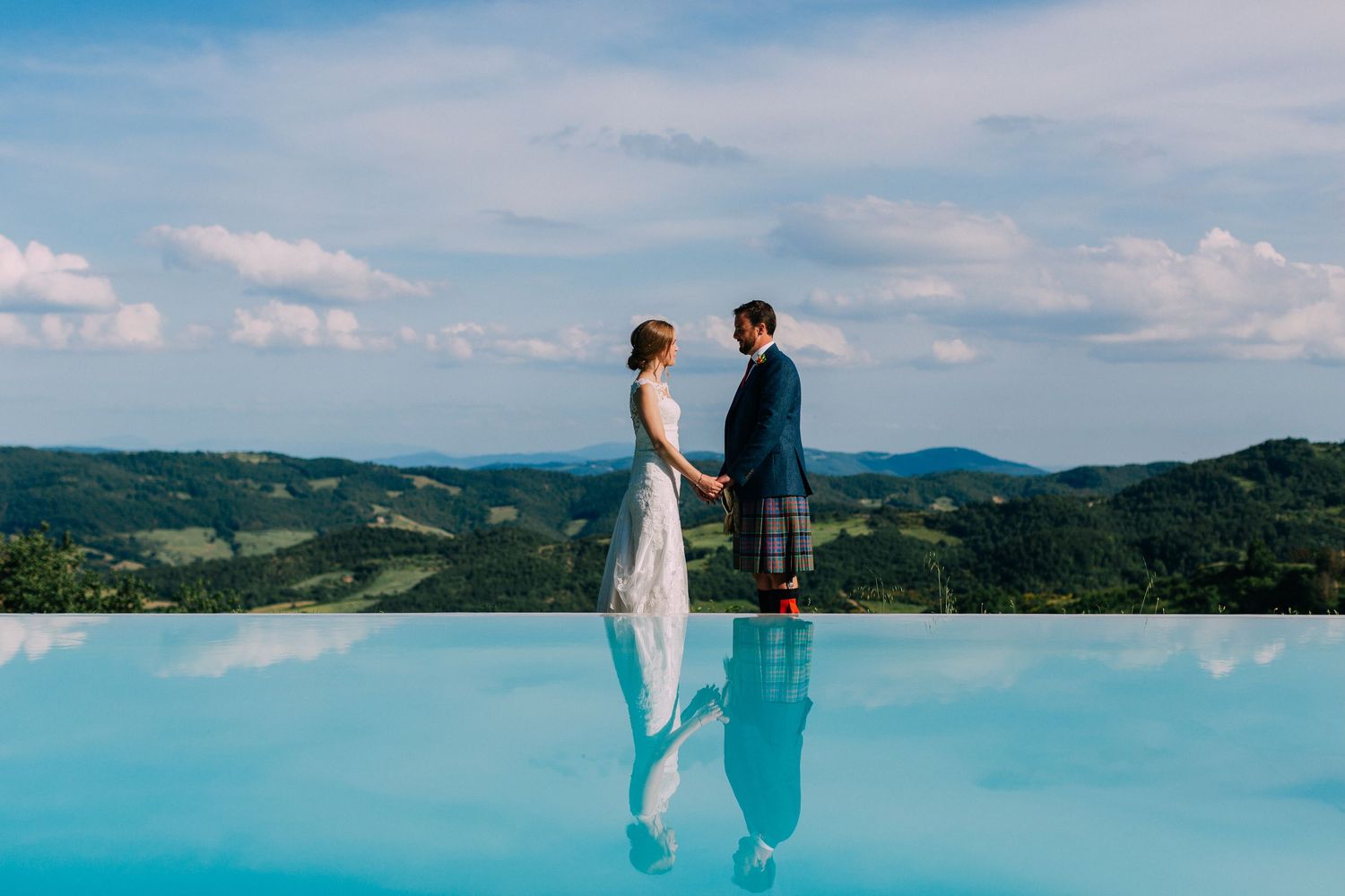 Scenic wedding portraits with mountains and blue water in the background.