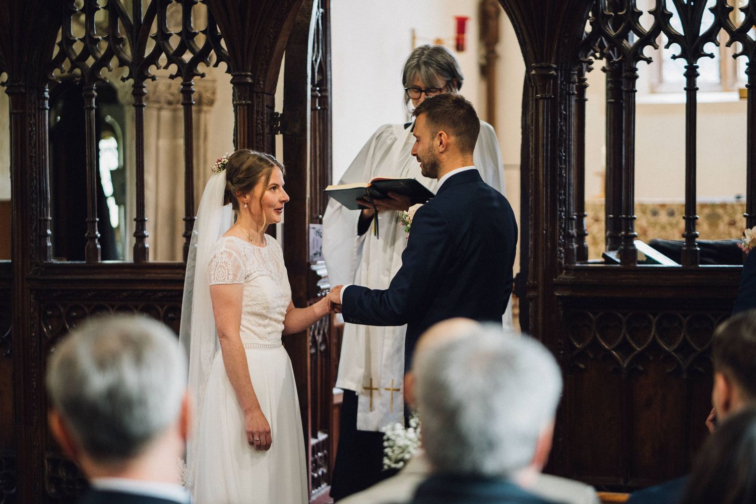 Wedding ceremony inside a historic church with gothic architecture and wooden pews.