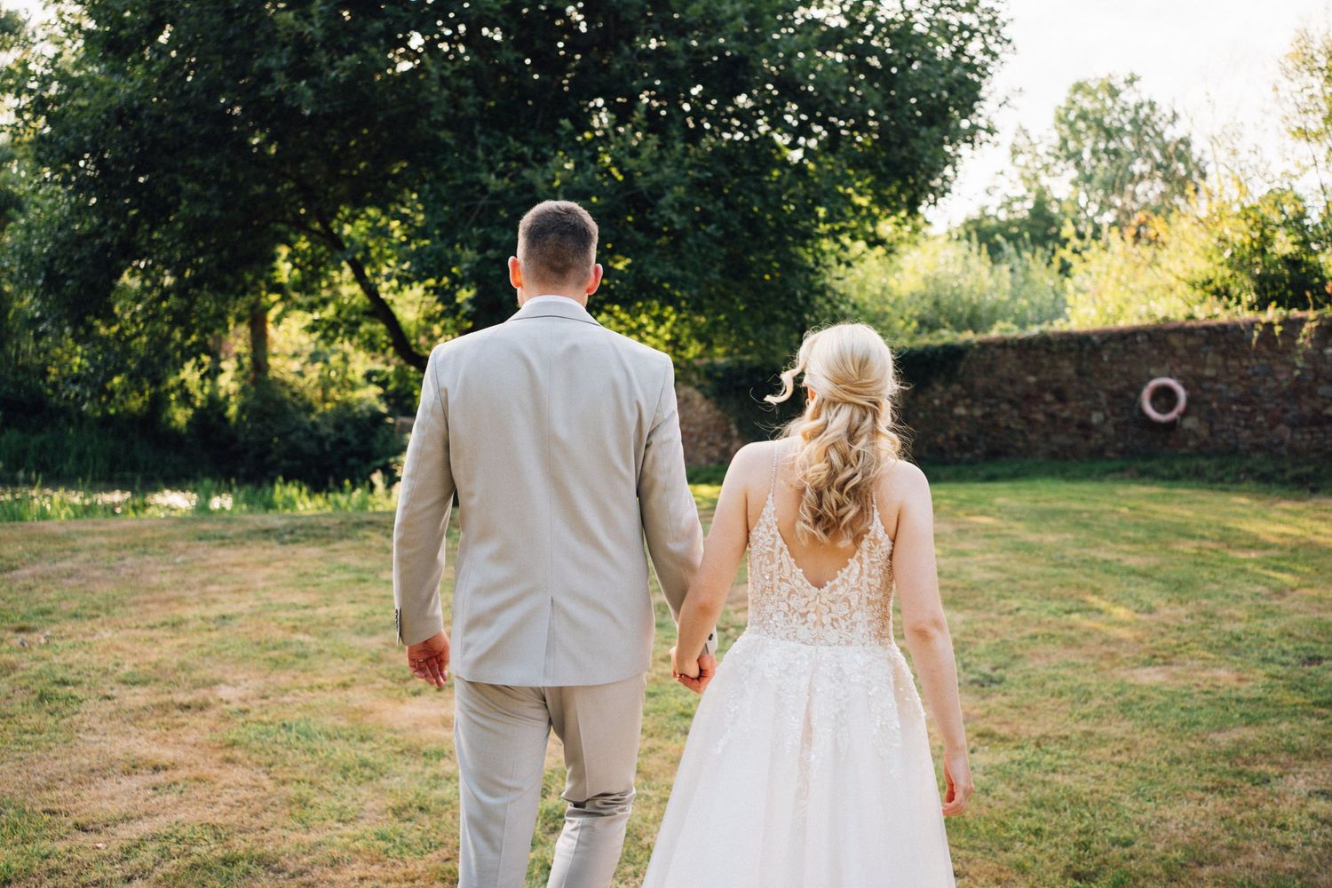 Scenic outdoor wedding venue shots showing a couple walking through a lush garden setting.