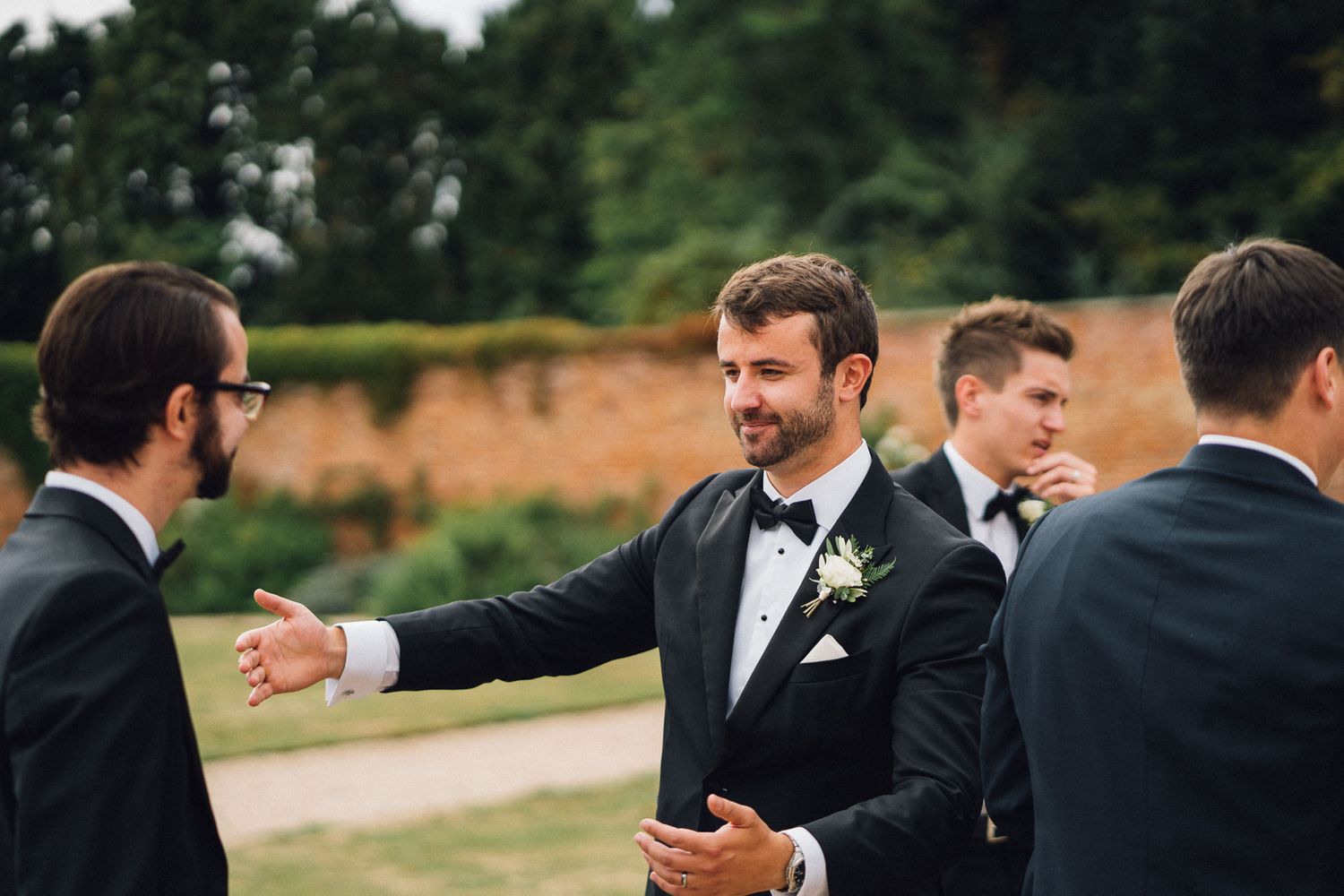 Groomsmen in formal attire celebrating outdoors during wedding festivities.