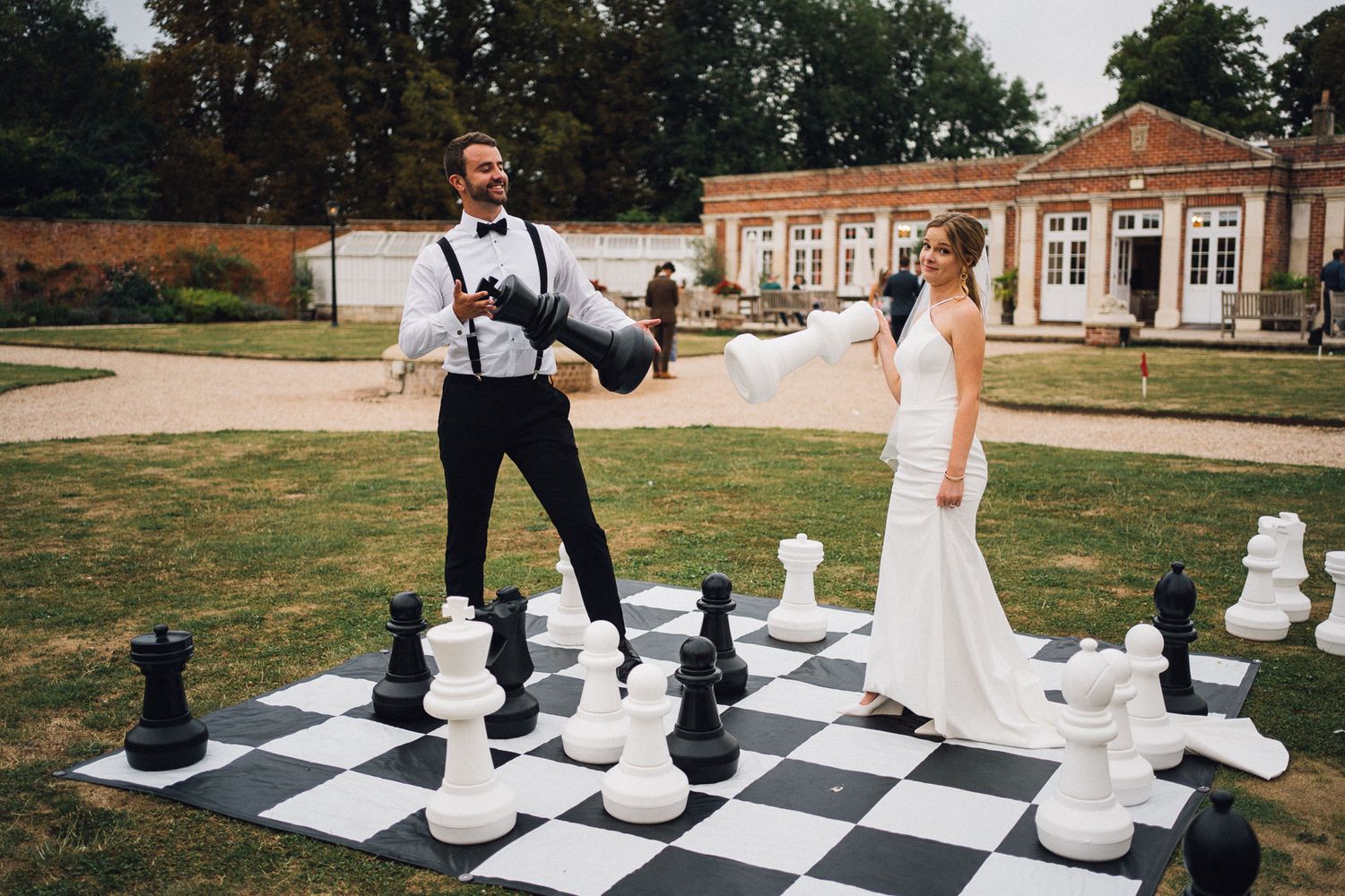 Newlyweds enjoy a game of oversized chess on their wedding day.