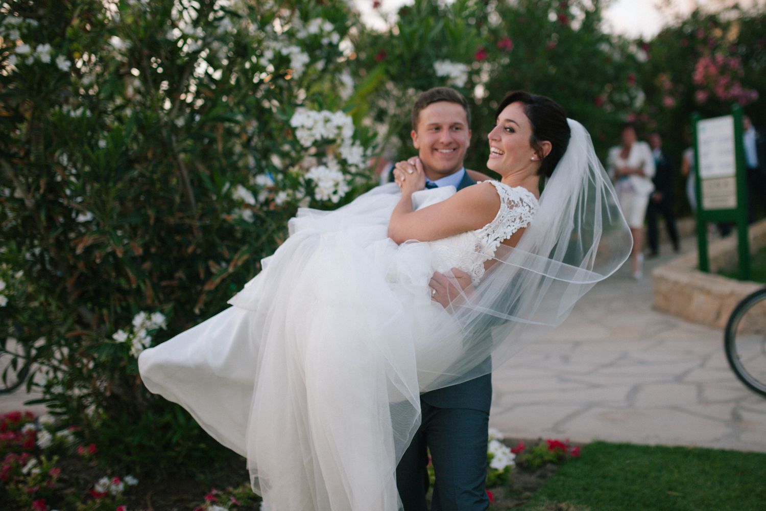 A couple shares a romantic dance moment in a garden setting during their wedding celebration.