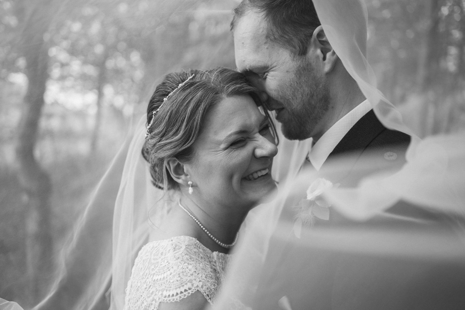 Romantic black and white wedding portraits showing intimate moments between couples in a dreamy outdoor setting.