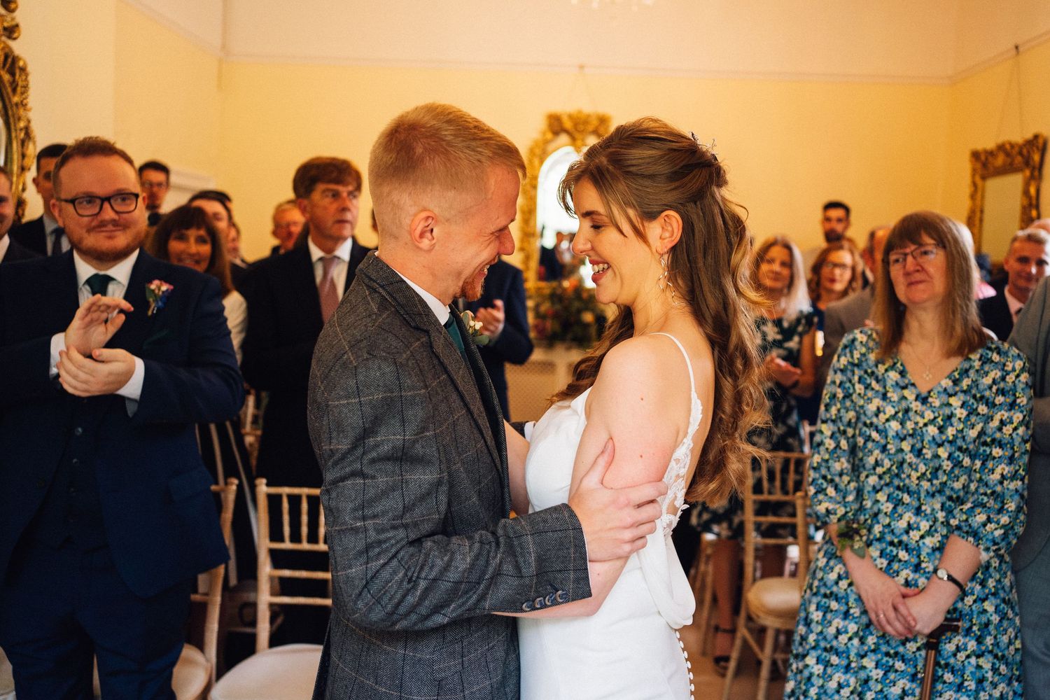 Wedding celebration in a warmly lit room with guests mingling and celebrating.