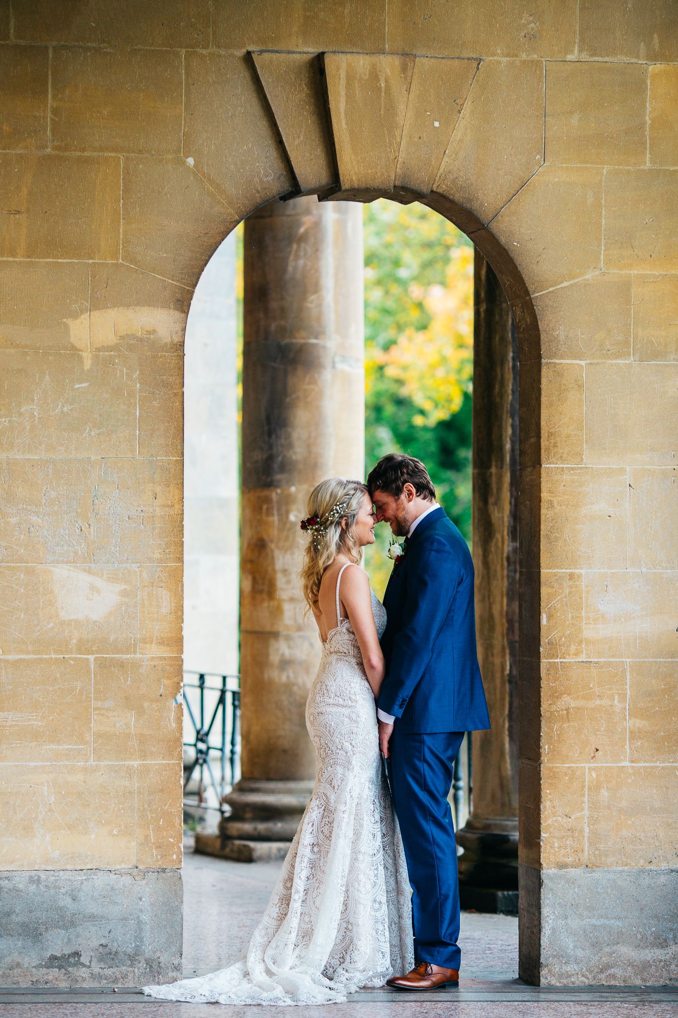 Wedding portraits under stone archways and columns at historic venue.