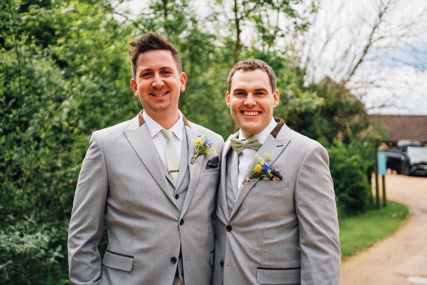 Wedding party members in gray suits pose for formal portraits in an outdoor setting.