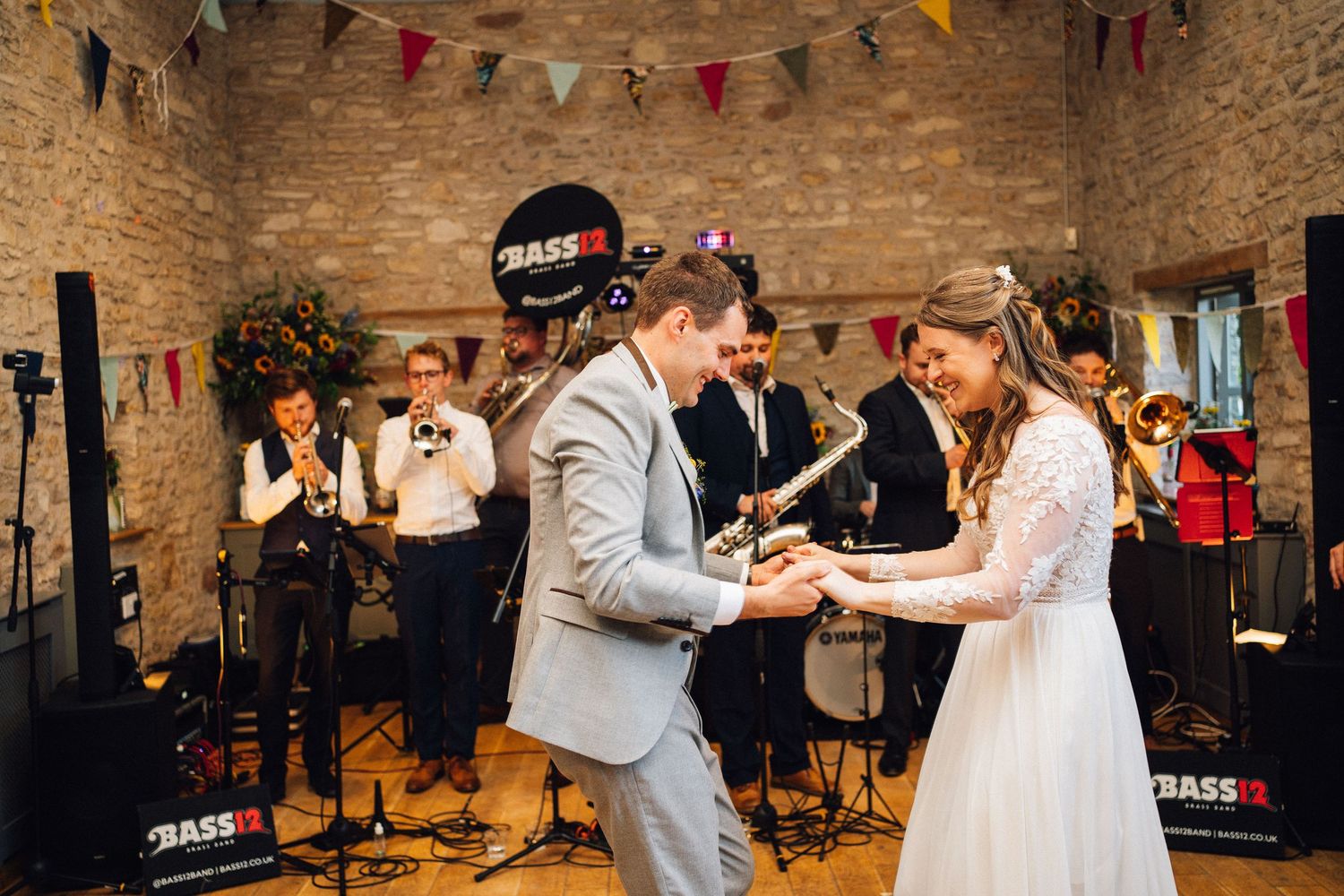 Wedding celebration in a rustic stone barn decorated with colorful bunting flags.