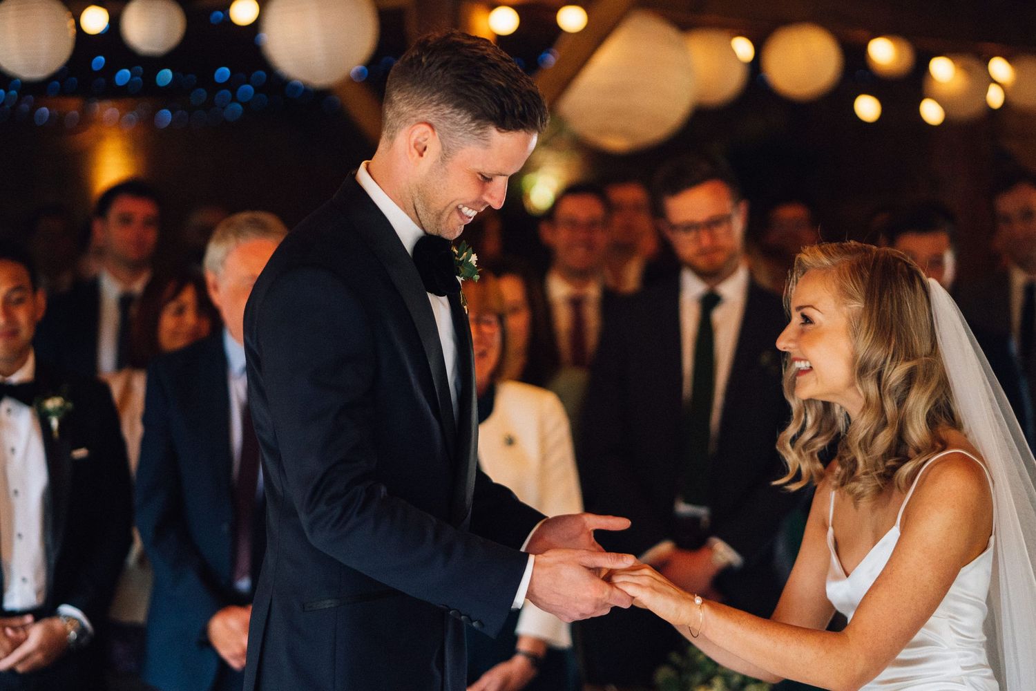 Wedding ceremony under warm lighting with paper lanterns and romantic ambiance.