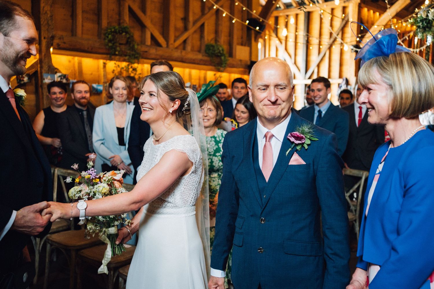 Guests gathered in a warmly lit barn for a wedding celebration.