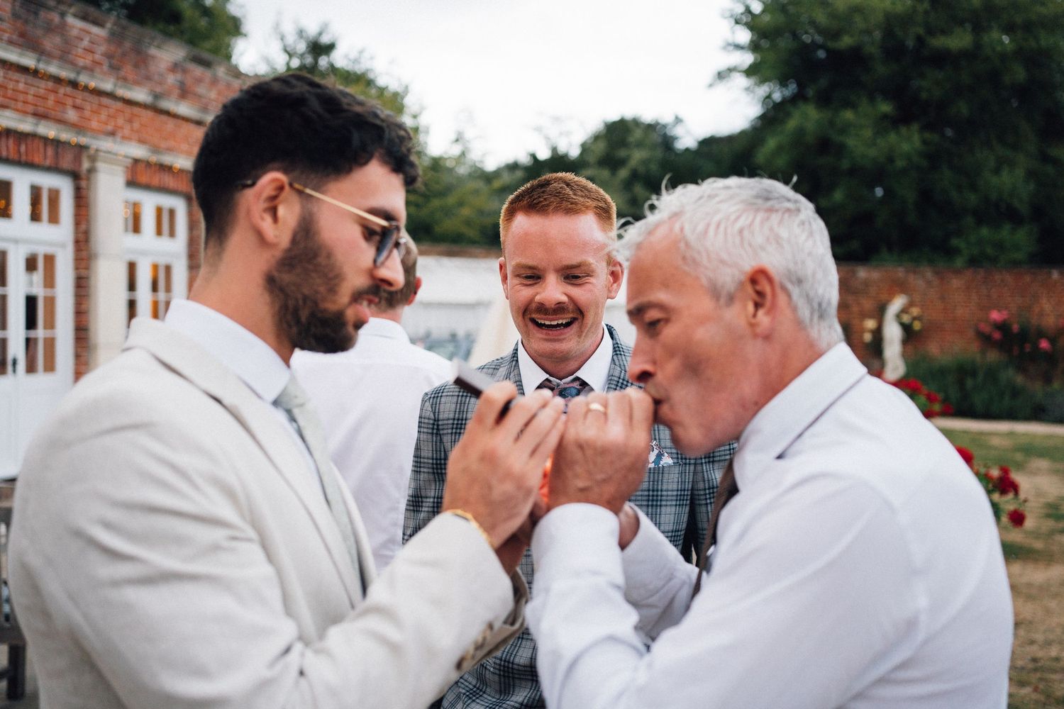 Emotional moments shared between wedding party members during outdoor celebration at brick venue.
