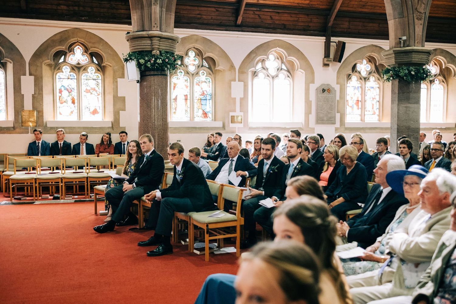 Wedding ceremony in a grand church with ornate architecture and stained glass windows.