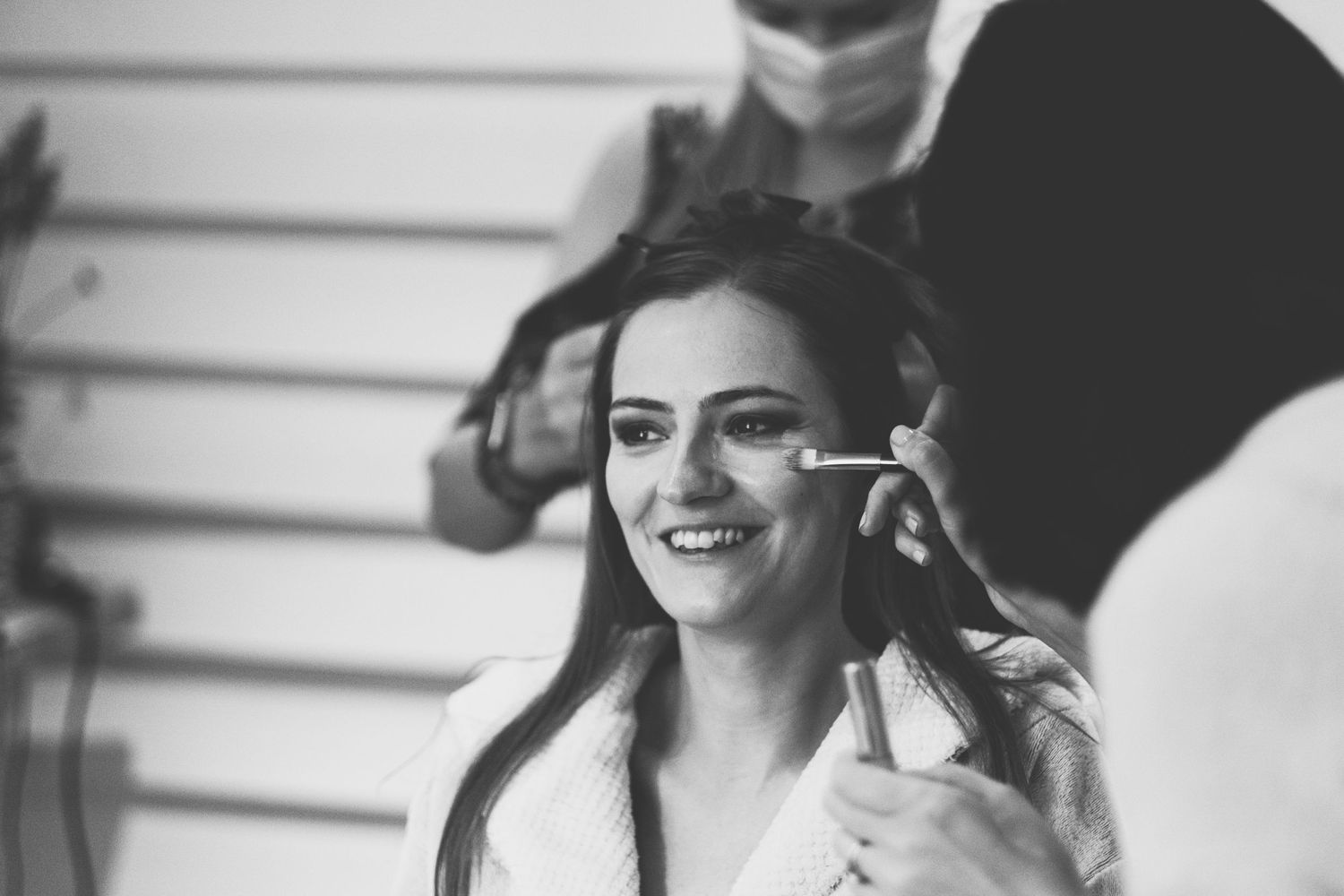 A candid moment during wedding day makeup preparation.