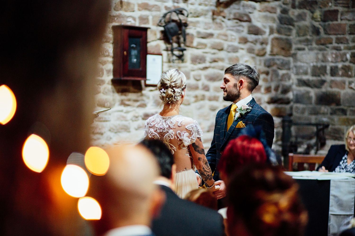 Wedding celebration in an intimate brick-walled venue with warm lighting.