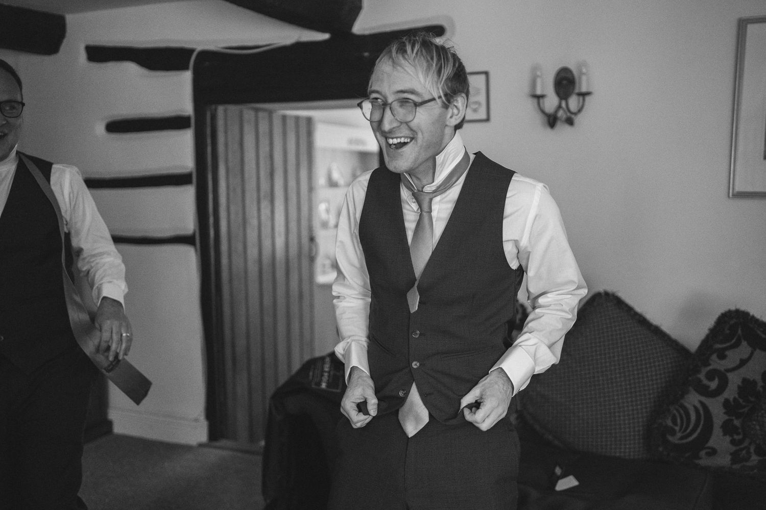 Groomsmen in navy vests and white shirts getting ready for a wedding ceremony.