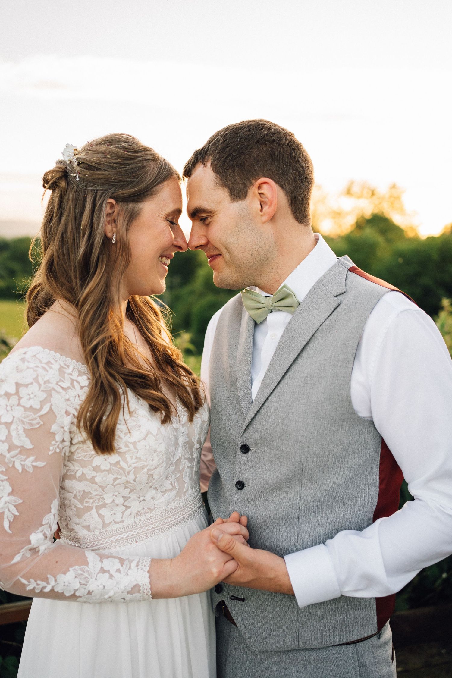 Romantic couple in wedding attire share intimate moments during sunset portrait session.