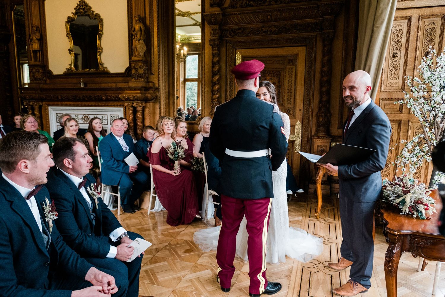 Elegant wedding reception in an ornate indoor venue with guests mingling.