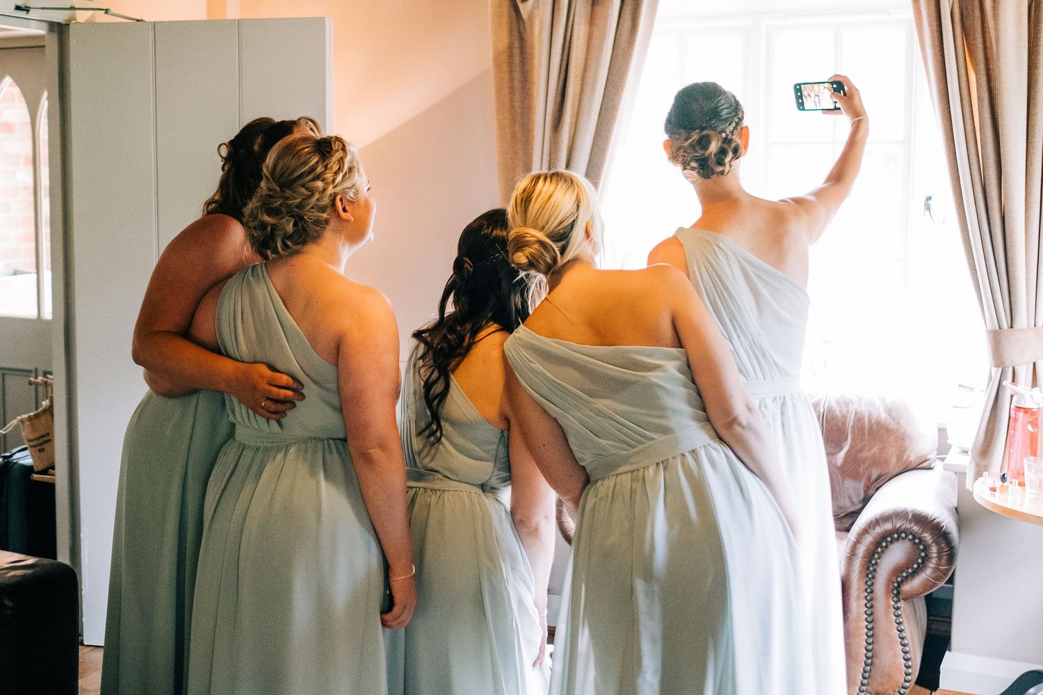 People in sage green dresses preparing for a special occasion.