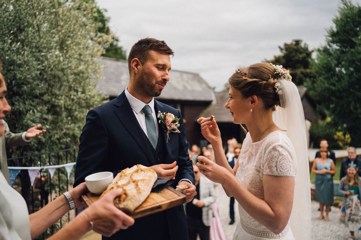 A couple shares a traditional bread and salt ceremony at their wedding reception.