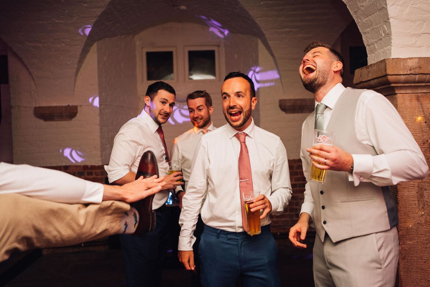 Wedding guests dance and celebrate enthusiastically during a lively reception party.