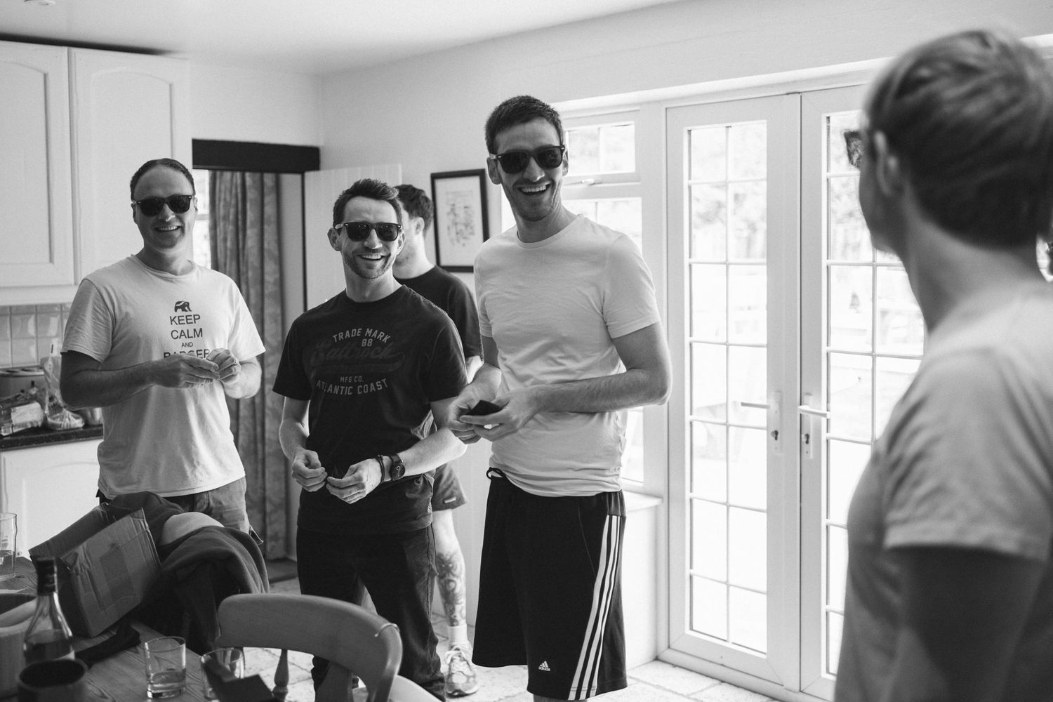 A group enjoying beverages in a bright, sunlit room with white walls.