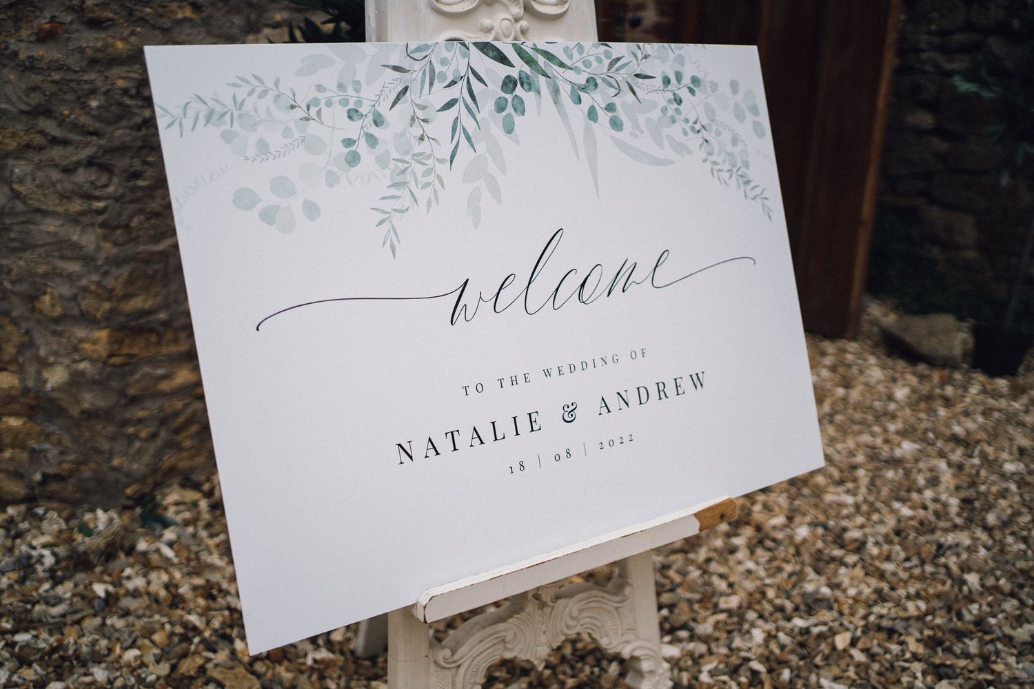 Elegant wedding invitation cards with floral designs and calligraphy displayed on stone surface.