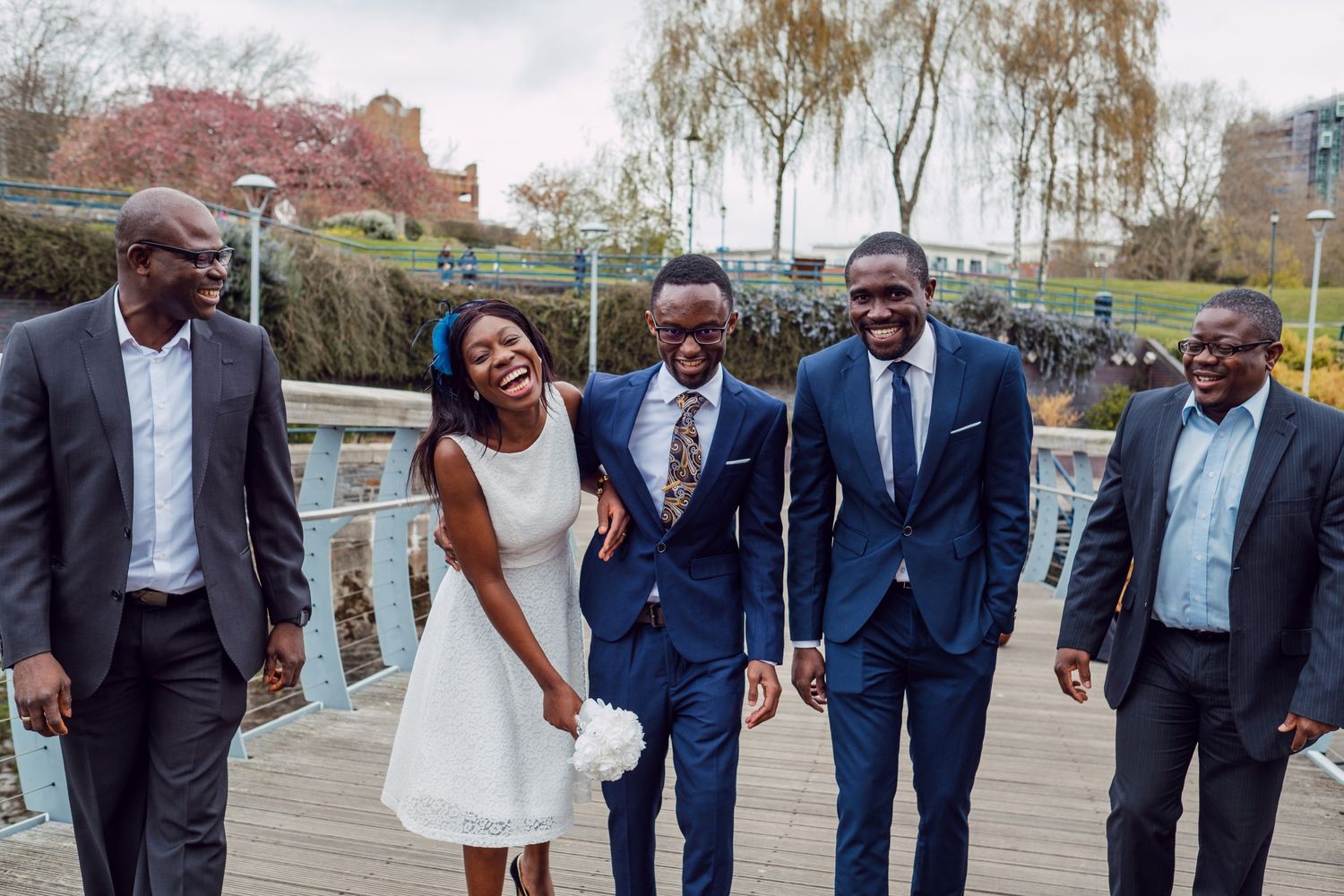 A group poses together outdoors near a waterfront setting.