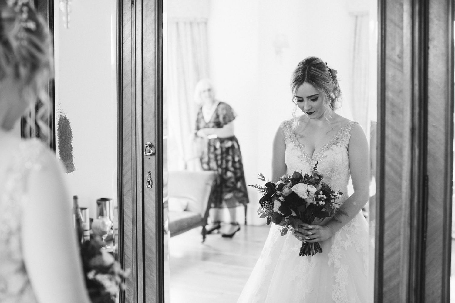 Black and white wedding photography capturing romantic moments in a hallway.