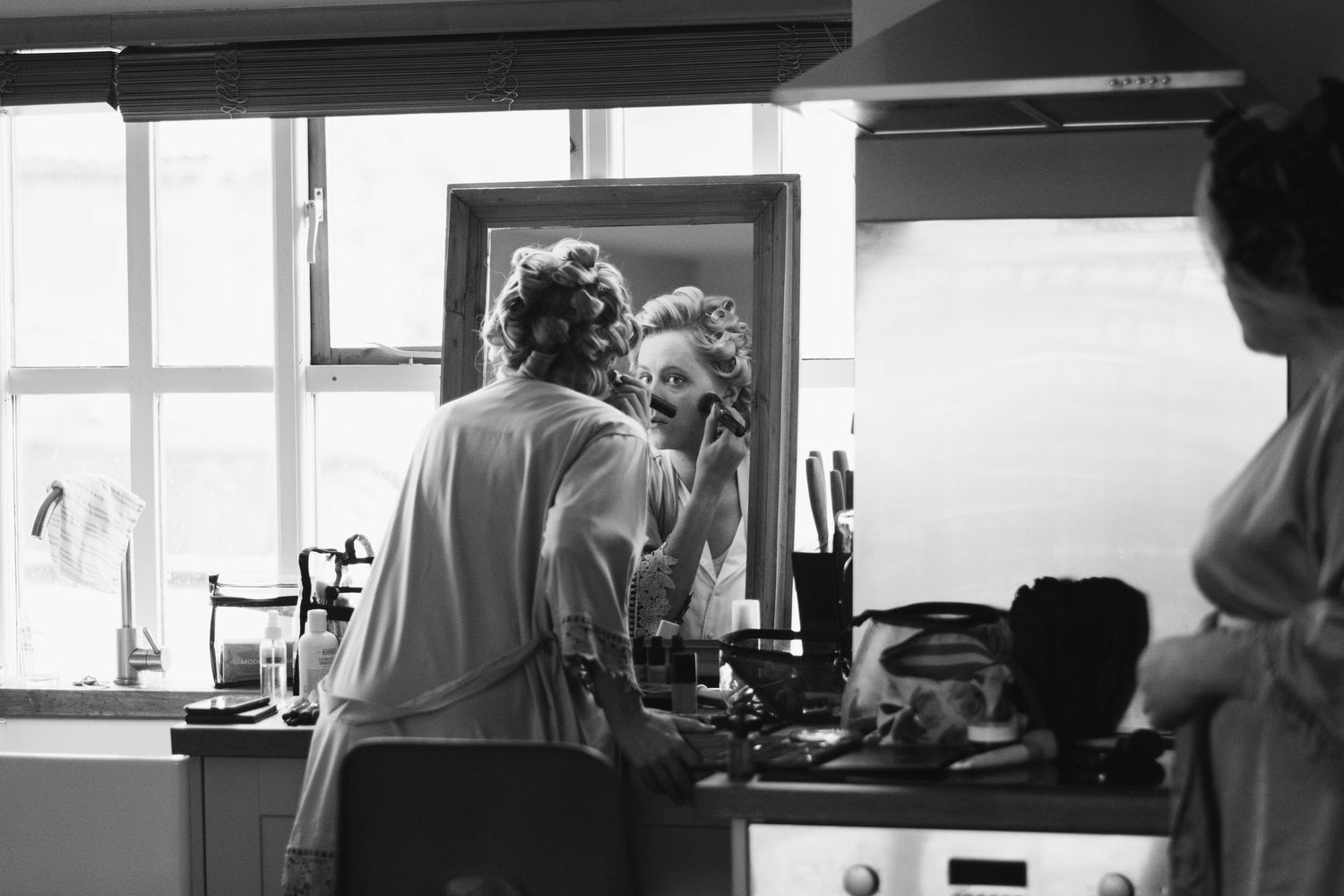Black and white interior scene showing kitchen staff working in a commercial venue space.