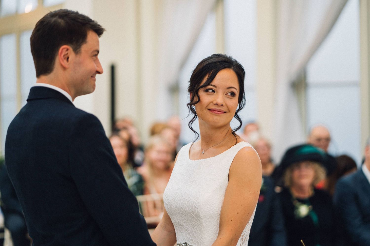 Joyful wedding celebration with guests gathered in an elegant white-draped venue.