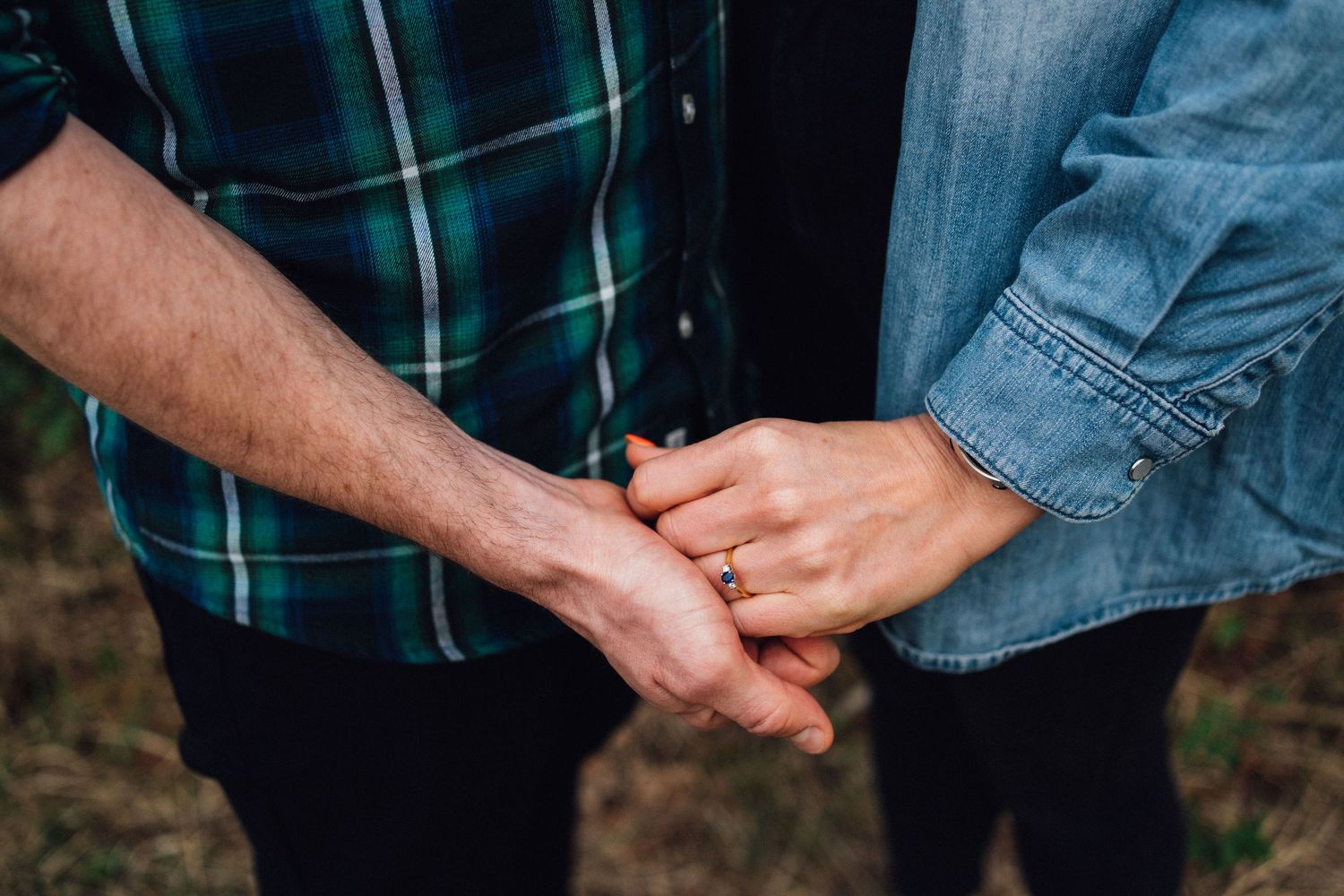 Close-up details of hands and casual clothing during an outdoor photo session.